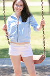Such a cute girl having fun on the swings and peeking out her tits then covering them with her hands
